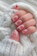 Close-up of a hand with pink and gold glittery nail polish on a soft white background, Obroi