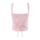 A light pink floral print camisole top with a square neckline, scalloped lace trim, and a drawstring tie at the waist, shown against a plain white background, Obroi