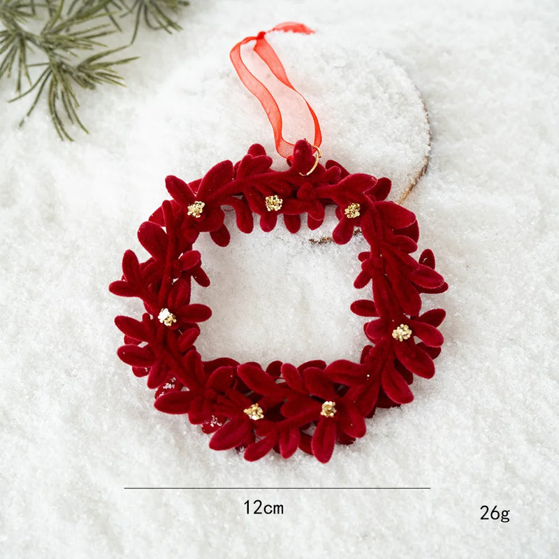 Red decorative wreath ornament with gold accents on a snowy background, Obroi