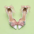 White high-heeled shoes with pink floral decorations on a light green background, Obroi