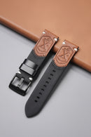 Black and brown leather watch strap with embossed design on a gray surface, Obroi