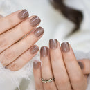 Close-up of a hand with brown nail polish on a blurred background, Obroi