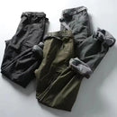Three pairs of pants in black, green, and gray on a light gray background, Obroi