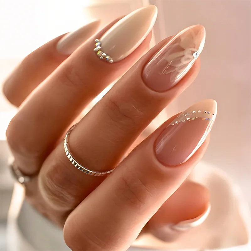 Close-up of a hand with almond-shaped nails and silver rings on a soft background, Obroi