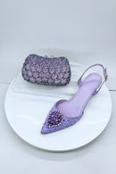 Purple stiletto shoes and matching clutch on a white plate, Obroi