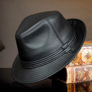 Black leather hat on a decorative box with a dark background, Obroi