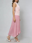 Woman wearing a pink dress with a pleated skirt on a gray background, Obroi