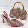 Pink high-heeled shoe and matching embellished handbag on a textured white background, Obroi
