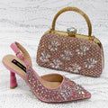 Pink high-heeled shoe and matching embellished handbag on a textured white background, Obroi