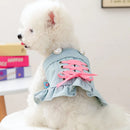 Small dog wearing a denim dress with pink laces on a white surface, Obroi