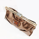 A metallic bronze clutch bag with a gold-tone frame closure and large crystal embellishments, shown on a white background with the Obroi brand logo in the top left corner.