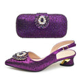 Purple shoe and matching handbag set with decorative elements on a white background, Obroi