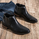 Black leather boots on a wooden floor with jeans in the background ,Obroi