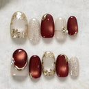 Nail art display with red and gold designs on a white background, Obroi