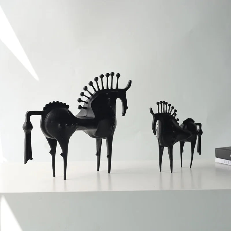 Black horse-shaped chairs on a white surface with a white background, Obroi
