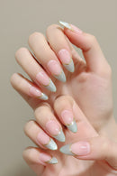 Hand with pink and gold nail design on a neutral background, Obroi