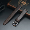 Two brown leather watch straps on a dark surface with an old book in the background, Obroi