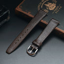 Two brown leather watch straps on a dark surface with an old book in the background, Obroi