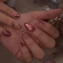 Close-up of a hand with decorative nail art featuring flowers and gold accents, Obroi
