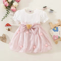 White dress with pink skirt and bow on a light background