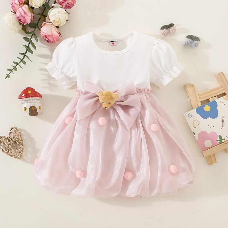 White dress with pink skirt and bow on a light background