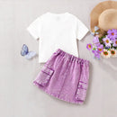 White t-shirt with a purple denim skirt on a light gray background, accompanied by a straw hat and flowers, Obroi