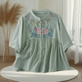 Light green blouse with floral embroidery on a white surface, Obroi