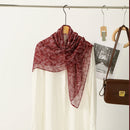 Red scarf draped over a mannequin with a white shirt underneath, on a hanger against a neutral background, Obroi