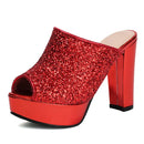 A single red glitter platform mule sandal with a chunky block heel, shown from a three-quarter angle on a white background, Obroi