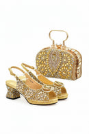 A gold embellished women's evening set featuring a pair of slingback peep-toe high heels and a matching handbag, both covered in rhinestones and crystals, shown on a white background with the brand name Obroi