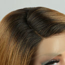 Close-up of a lace front wig with dark brown to light brown ombre highlights, showing the hair part and fine lace mesh attachment against a neutral background, Obroi