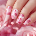 Nails with pink heart design on a blurred pink background, Obroi