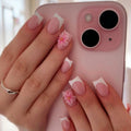 Pink phone with floral nail art on a blurred background, Obroi