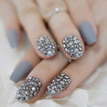 Nails with gray polish and decorative studs on a neutral background, Obroi