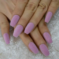 Close-up of hands with pink textured nails on a glittery surface ,Obroi