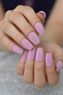 Close-up of a hand with pink textured nails against a blurred background ,Obroi