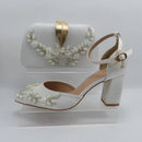 White wedding shoe with decorative embellishments and matching handbag on a white background, Obroi