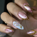 Close-up of a hand with pink and gold nail art on a blurred background, Obroi
