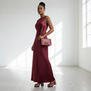 Woman in a burgundy dress holding a matching handbag in a bright room, Obroi