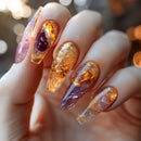 Nails with gold and purple glitter design on a blurred background, Obroi
