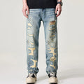Distressed blue jeans worn by a person on a white background
