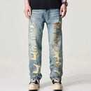 Distressed blue jeans worn by a person on a white background