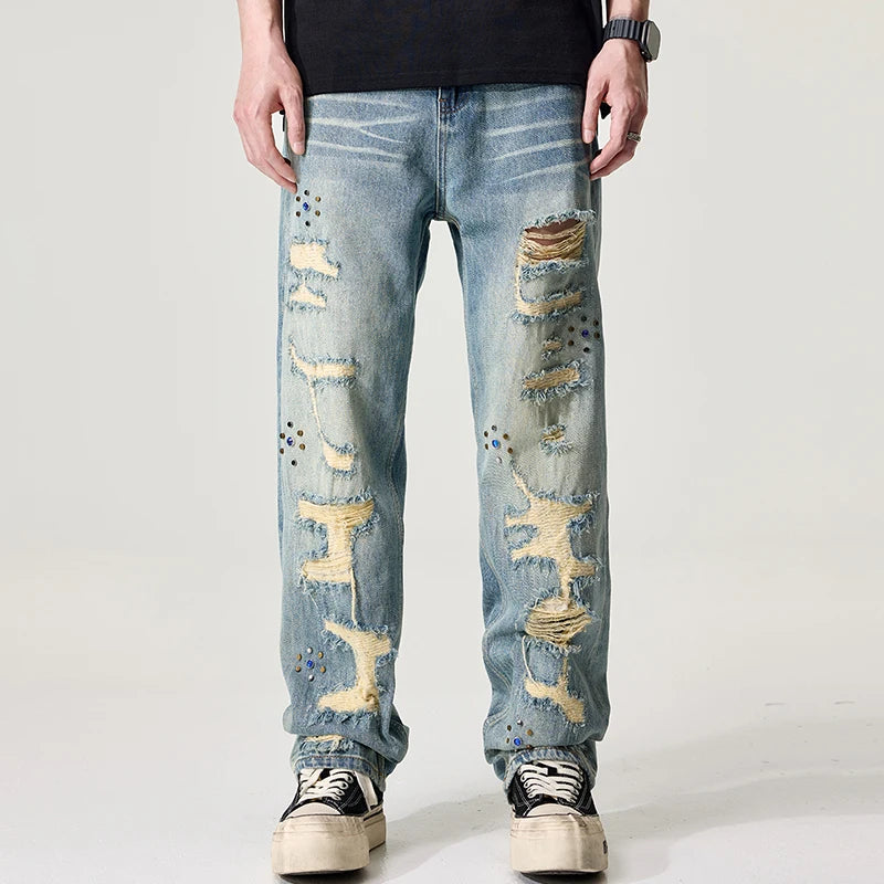 Distressed blue jeans worn by a person on a white background