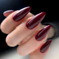 Hand with burgundy nail polish on a blurred background, Obroi