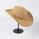 Woven straw hat on a black stand against a white background, Obroi