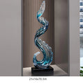 Obroi decorative glass sculpture with wavy design on a stand, set against a neutral background.