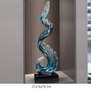 Obroi decorative glass sculpture with wavy design on a stand, set against a neutral background.