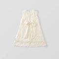 An ivory sleeveless lace dress for toddlers, featuring a large satin bow at the center front, scalloped lace trim, and embroidered floral details, shown against a light gray background, Obroi