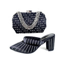 Black studded shoe and matching handbag set on a white background, Obroi