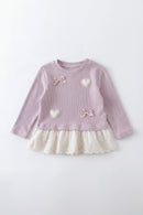 Pink ribbed dress with white heart and bow details on a light gray background, Obroi